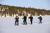 People walking with snowshoes on frozen lake, Yellowknife, Northwest Territories, Canada