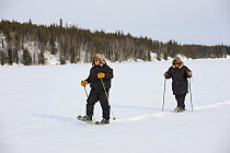 People walking with snowshoes on frozen lake, Yellowknife, Northwest Territories, Canada