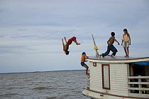 Children jumping off a boat at Freguesia do Andirá village, municipality of Barreirinha, Amazonas State, Northern Brazil.