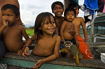 Children with pet Titti monkey at their riverside house on shore of the Amazonas River, near Terra Santa town, Pará State, Northern Brazil. 2006