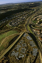 Aerial view of freeway and housing construction in coastal sage scrub habitat, North San Diego County, California. Dec 2002.