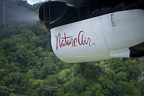 'Nature Air' aircraft flying over rainforest. This airline is carbon neutral, offsetting their carbon use by buying rain forest in the Osa Peninsula. Golfito, Puntarenas, Costa Rica.