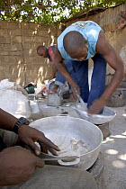 Artisans filing down aluminium pots made from reclaimed metal, The Gambia, 2008