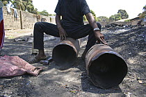 Gambian man breaking apart reclaimed gas canister, The Gambia, 2008