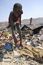 Gambian girl sifting for aluminium scrap, Mannjai Kunda rubbish dump, The Gambia, 2008