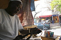 Craftsman cutting up discarded drinks cans, Dakar, Senegal, 2008