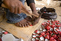 Artisan hammering holes into coke bottle tops, Dakar, Senegal, 2008