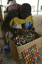 Artisan putting old bottle tops onto wire, Dakar, Senegal, 2008