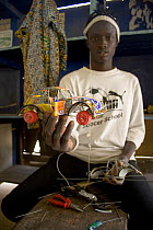 Artisan with toy car crafted from recycled materials, Dakar, Senegal, 2008