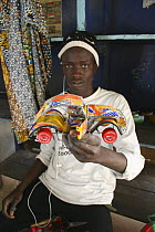 Artisan with toy car crafted from recycled materials, Dakar, Senegal, 2008