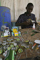 Artisan apprentice making toy car from recycled materials, Dakar, Senegal 2008