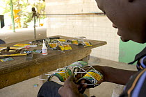 Artisan apprentice making toy car from recycled materials, Dakar, Senegal, 2008