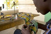 Artisan apprentice making toy car from recycled materials, Dakar, Senegal, 2008