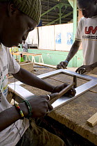 Artisan crafting picture frame from recycled metal, Dakar, Senegal, 2008