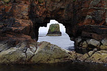 View of coast through rock arch, Papa Stour island, Shetland Islands, Scotland, UK