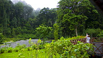 Tourists viewing the rainforest from the terrace of a wildlife lodge, Danum valley forest reserve, Sabah, Borneo, Malaysia 2007