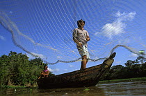 Caboclo man throwing fishing net. Curicaca, Amazon, Brazil, 1993.
