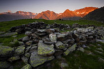 Old rock enclosure for cattle in Toran valley, with Tuc d'Ermer peak in the background, Aran Valley, Pyrenees, Spain.