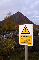 Spoof risk sign in front of Buachaille Etive Mor, Argyll, Scotland, UK, October 2007