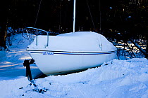 Small sailing-boat on a trailer covered in thick snow. Mount Tremblant, Quebec, Canada, 2008.