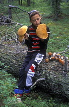Girl with edible Bolete mushroom (Leccinum auranthacum) from Taiga forest, Siberia, Russia