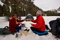 Skier Phil Atkinson (right) and photographer Tim Laman camp at Big Park Lake, Beartooth Mountains, Montana, USA. May 2008