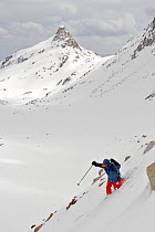 Skier Phil Atkinson skiing down slopes of the upper Sky Top Lakes Valley, near Granite Peak, Beartooth Mountains, Montana, USA. May 2008