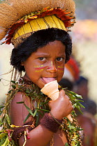 Child in traditional costume, licking icecream, at Goroka Cultural Show in the Eastern Highlands Province, Papua New Guinea. September 2004