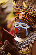 Woman appying face paints for traditional ceremony, Mount Hagen, Western Highlands Province, Papua New Guinea. September 2004