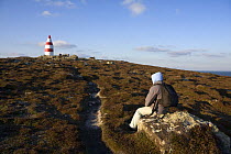 Walker sitting near the Daymark, erected in the 1600s. St.Martin's, Isles of Scilly December 2008.