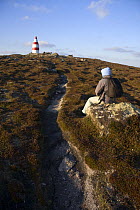 Walker sitting near the Daymark, erected in the 1600s. St.Martin's, Isles of Scilly December 2008.