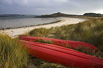 Kayaks pulled up in the dunes on Old Grimsby Beach, Tresco, Isles of Scilly. December 2008.