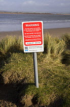 Coastal warning sign for tidal waters and mudflats on Westward Ho! beach, North Devon. January 2009.