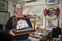 Miniature shipwright, Malcolm Darch, with model boat in his workshop. Salcombe, Devon, UK. January 2009.