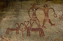 Prehistoric rock painting of men and horned animals in the riverbed of Dungarinala, near Golpur, Rajasthan, India