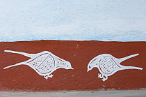 Traditional painting of two birds on mud wall of house during Diwali festival, Bada Gaire Killa village, South of Tonk, Rajasthan, India