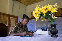 Woman writing out permits to allow visitors into the Daraina forest, where the last Golden Crowned Sifakas (Propithecus tatersalii) live, Daraina, Northeast Madagascar.