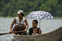 Family in dugout canoe on lake, Camarines Sur, Luzon, Philippines 2008
