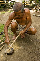 Man preparing bamboo chimes as one of the livelihood products to sell, Camarines Sur, Luzon, Philippines 2008