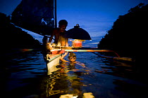 Fisherman and son on traditional sailboat out for night fishing using a kerosine "Petromax" lamp to attract fish, Camarines Sur, Luzon, Philippines 2008.