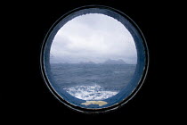 The first sight of South Georgia from boat window, Southern Ocean, Antarctica. November
