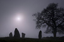 Low winter sun shining through thick fog above Nine Stone Close stone circle, Peak District NP, Derbyshire, UK. 2006