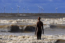 One of Anthony Gormley's Another Place sculpture in the sea with offshore windfarm in distance, Crosby, Liverpool, October 2008