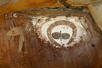 A rock art shelter in the northern Kimberley region features a cluster of Wandjina figures peering out from the sandstone rock surface, Northern Kimberley region and the Mitchell Plateau, Western Aust...