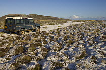 Light covering of snow with a Land Rover on a small track, Pebble Island, off north coast of West Falkland, Falkland Islands, November 2007