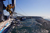 Crew member amongst ropes aboard Maxi yacht "Banque Populaire V", skippered by Pascal Bidegorry, practicing off Cadiz, Spain. March 2009.