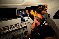 Checking the radar aboard Maxi yacht "Banque Populaire V", skippered by Pascal Bidegorry, practicing off Cadiz, Spain. March 2009.