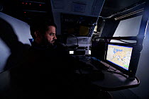 Skipper Pascal Bidegorry in the navigation room aboard Maxi yacht "Banque Populaire V", practicing off Cadiz, Spain. March 2009.