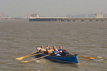 "Wolf" crew rowers in the Bristol Gig Club "Bristol Challenge" race with Avonmouth and Portbury Docks in the background. March 21st 2009.