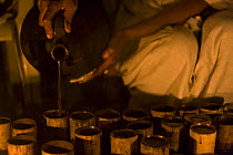 Coffee (Coffea arabica) poured from traditional terracotta pitcher into bamboo cups during ceremony, Bonga, Kaffa Zone, Southern Ethiopia, East Africa December 2008